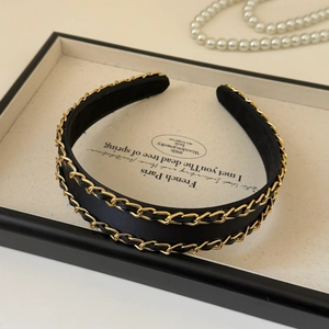 Detail of elegant black silk headband featuring twin gold chain and leather woven accents