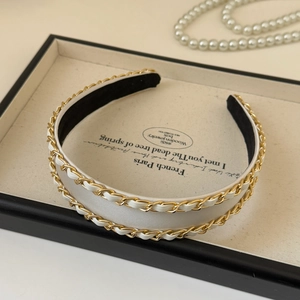 Detailed close-up of cream woven fabric headband with elegant double metal chain decoration