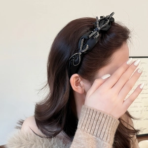 Elegante cerchietto in raso nero con strass brillanti indossato da una modella per capelli