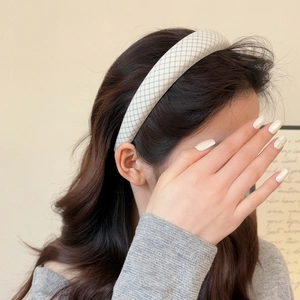 Close-up of a thick grey plaid headband on a model's hair for an elegant look