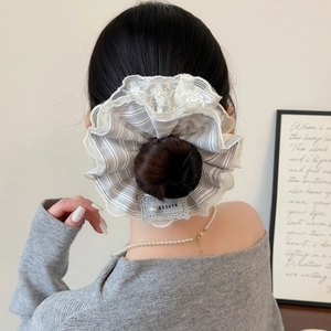 Striped oversized scrunchie with lace trim and pearl accent on a messy bun hairstyle