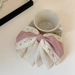 Close-up of a pink plaid lace bow hair clip with pearl charms and chiffon layers