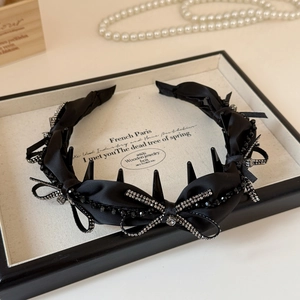 Dettaglio del cerchietto con fiocco di strass neri, denti antiscivolo e finitura in raso