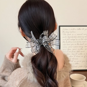 Elegant plaid bow hair tie scrunchie worn on a brown ponytail for a stylish look