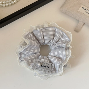 Close-up of grey striped scrunchie with lace trim and elegant pearl bead detail