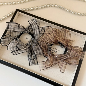 Close-up of checkered bow scrunchies with elegant bead accents and fabric texture