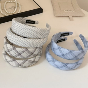 Detailed macro view of woven plaid headbands with high-quality handmade inner labels