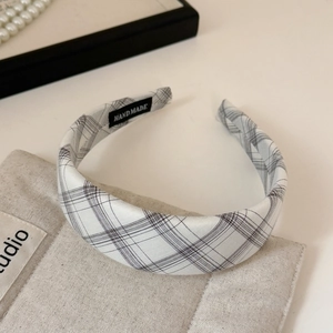 Detail of handmade plaid headband featuring high-quality woven fabric and handmade label