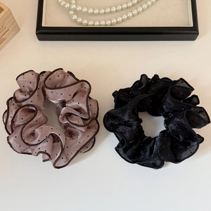 Detail of sweet mesh polka dot scrunchies in pink organza and pleated black fabric