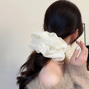 Elegant beige oversized scrunchie with floral embroidery for messy bun hairstyles