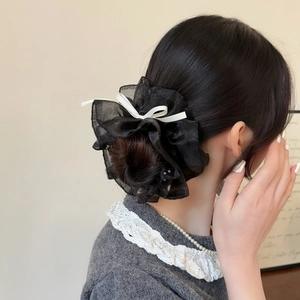 Chouchou en organza noir style français avec nœud blanc et perles sur un chignon