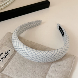 Detail of blue and white checkered fabric headband with handmade tag and soft texture