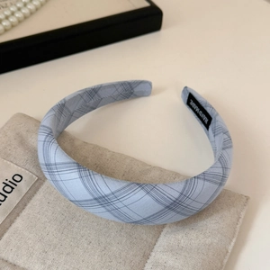Detail of light blue plaid headband showing the handmade label and soft cotton fabric