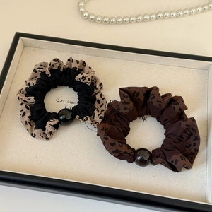 Elastic leopard print scrunchie set with black bead detail on a display tray
