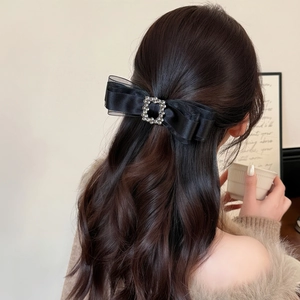 Elegant black double-layered bow hair clip with sparkling rhinestone buckle on hair