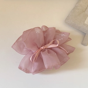 Détail d'un chouchou en organza rose avec perles blanches et un petit nœud en satin