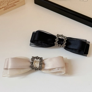 Elegant bow hair clips with organza layers and sparkling rhinestone buckles in black and white