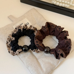 Detailed close-up of leopard print scrunchies with large polished decorative beads