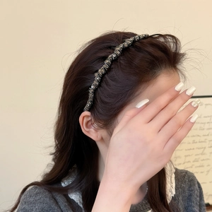 Serre-tête torsadé élégant avec strass et perles dorées et argentées sur un mannequin
