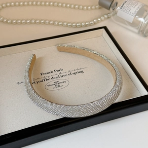 Detailed view of luxury silver rhinestone headband with soft brown velvet lining in display box