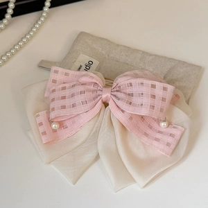 Detail of pink plaid and beige chiffon bow hair clip with white pearl pendants