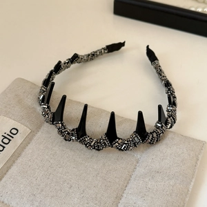 Gros plan du serre-tête antidérapant avec pointes noires punk et strass brillants