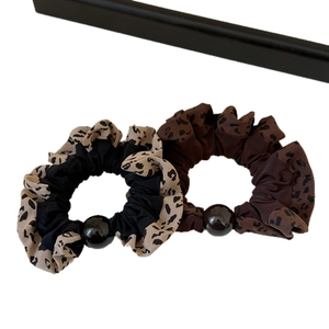 Elastic leopard print ruffle scrunchies with decorative round beads for stylish ponytails
