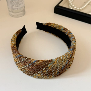 Detail shot of a wide tweed headband featuring vintage brown and blue woven texture