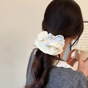 Elegante elastico in pizzo bianco con fiocco blu e perla su una coda di cavallo