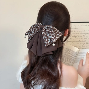 Elegant floral chiffon bow hair clip with pearl pendants in a French style ponytail look