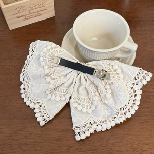 Bohemian off-white lace bow hair clip with spring fastener on a vintage wooden background