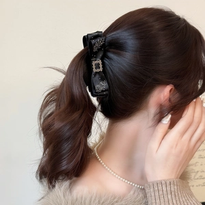Elegant black satin bow banana clip with crystal square buckle on model hairstyle