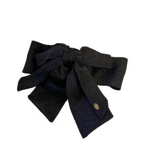 Elegant black bow hair clip with sparkling rhinestones and a gold metal accent plate