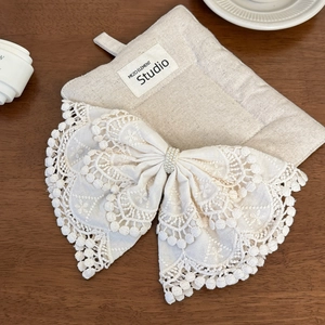Detail of a cream lace bow hair clip featuring exquisite embroidery and pearl center