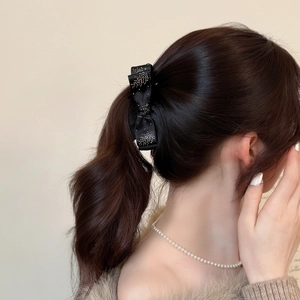 Elegant black bow banana clip with sparkling silver rhinestones on high ponytail