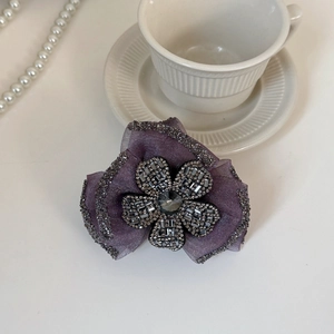 Detail of purple mesh flower hair claw with sparkling rhinestones and crystal petals