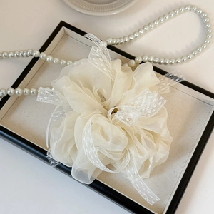 Gros plan détaillé du chouchou en organza blanc et dentelle sur un plateau à bijoux chic