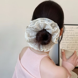 Plaid and lace oversized scrunchie hair tie shown in a stylish low bun hairstyle