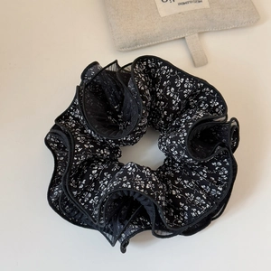 Dettaglio di elastico floreale nero con bordo in mesh multistrato e trama arricciata