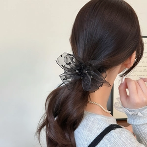 Elegant black tulle flower hair scrunchie with sequins on a low ponytail style