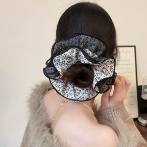 Elastico per capelli floreale con pizzo nero su elegante chignon con cardigan beige