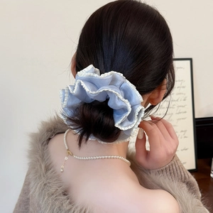 Elegant light blue pleated satin scrunchie with white lace trim on a bun hairstyle