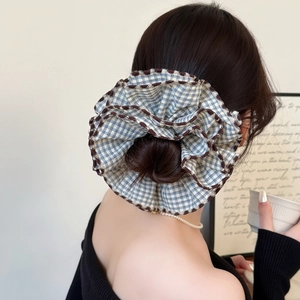Blue and white plaid scrunchie with brown wavy edges on a bun hairstyle for women