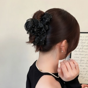 Chouchou élégant en organza noir à pois blancs présenté sur un chignon de cheveux