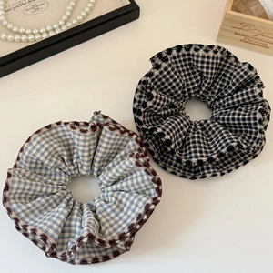 Blue and black plaid scrunchies with wavy edges displayed on a white background