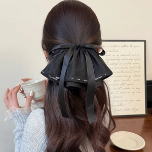 Elegant large black satin bow hair clip with pearl edges and long ribbons for women