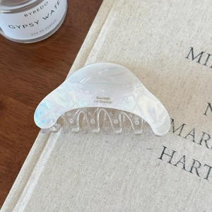 Détail d'une pince à cheveux blanc nacré avec inscription Barrette La France dorée
