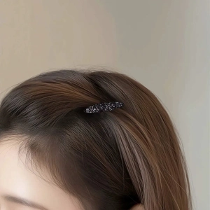 Elegant dark rhinestone hairpin with shimmering crystals on brown hair side view