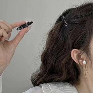 Elegant black rhinestone hair clips with spindle design shown in hand and on hair