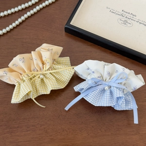 Close-up of floral and plaid scrunchies with ribbons and small pearl pendants